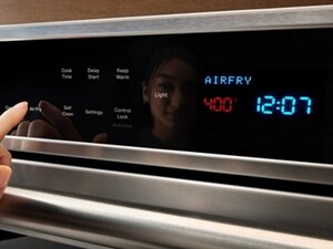 Reflection of woman setting her oven to the air fry setting