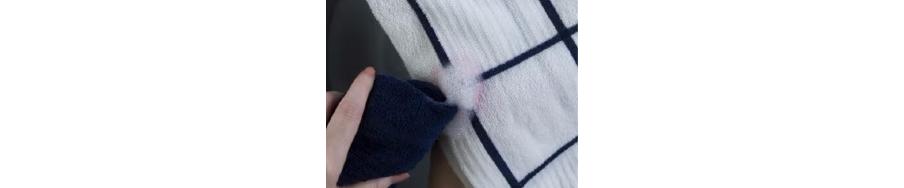 Person spot-treating a stain on a white washcloth