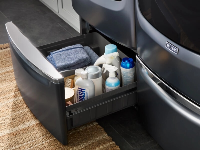 Laundry and cleaning supplies in pedestal below washer