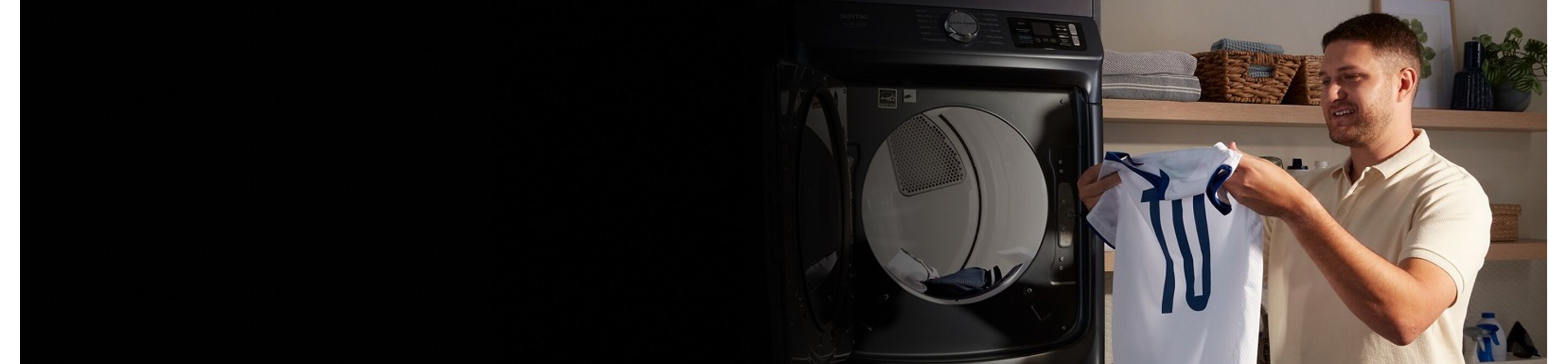 Person removing a jersey from a dryer