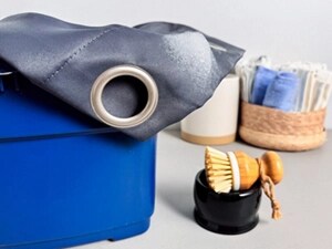 A blue curtain with a rung in a bucket next to a small scrub brush