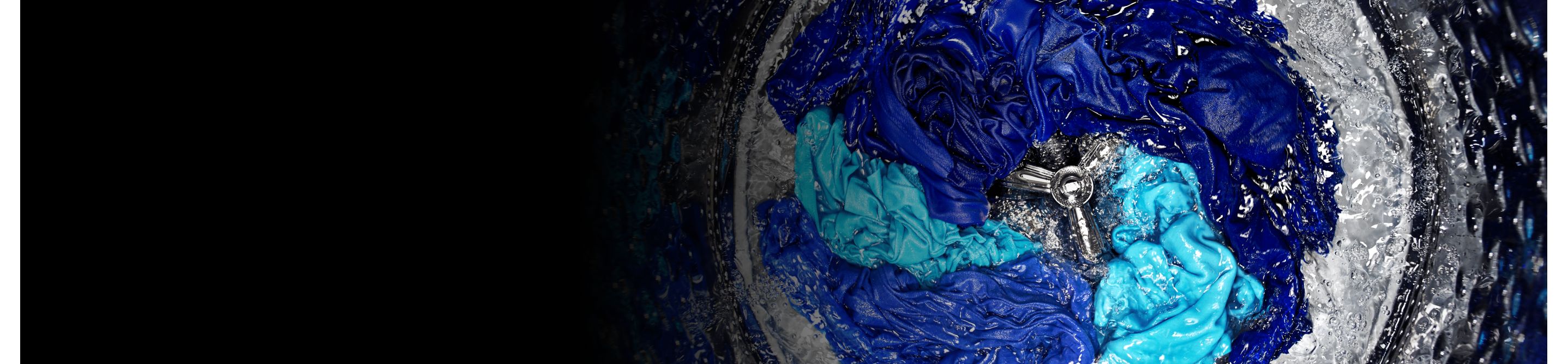 Assorted blue clothes agitating in the washer