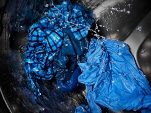 Wet blue clothes being washed in a washing machine