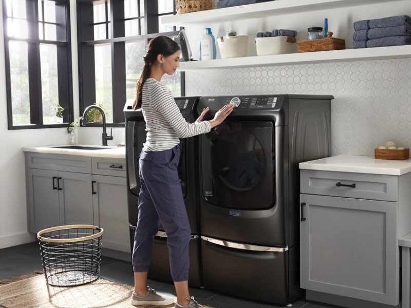 Person starting their load on a Maytag® dryer