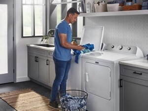 Person adding a load of laundry to their washer
