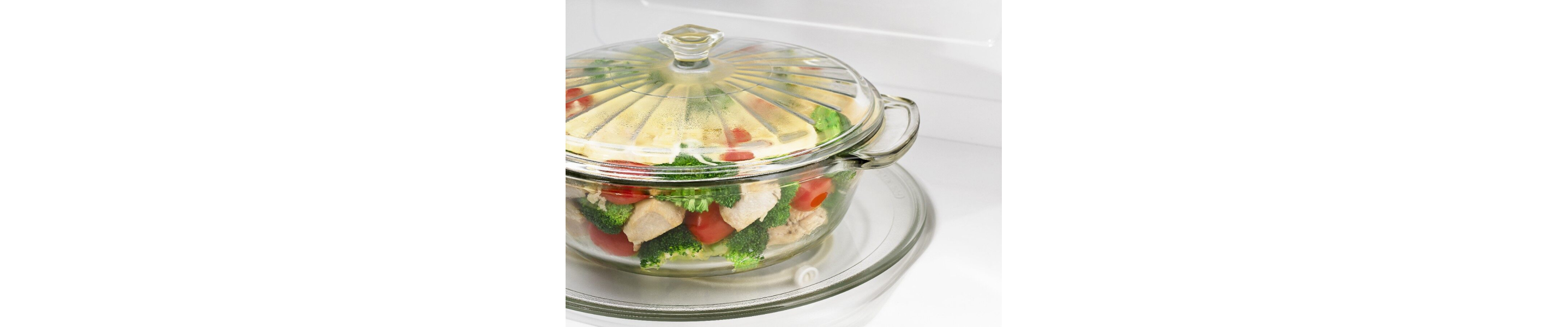 A closeup of a glass bowl of steaming vegetables in a Maytag® microwave