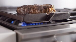 Steak searing on a gas stovetop griddle attachment