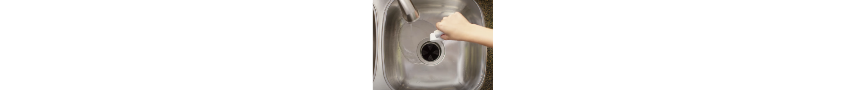 A person dropping an affresh® disposal cleaner tablet down the drain