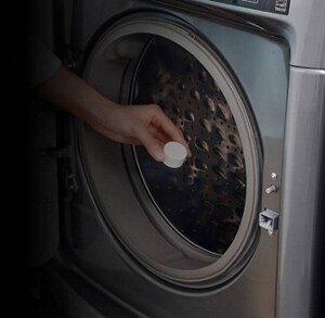 Person using affresh® tablet in washing machine