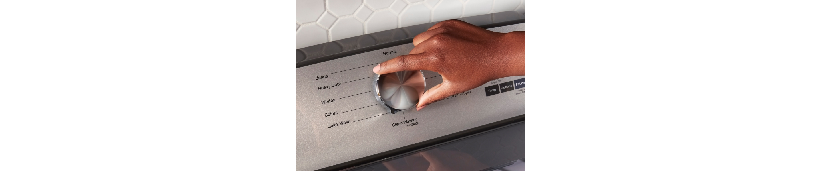 Hand selecting a wash cycle on a Maytag® washing machine