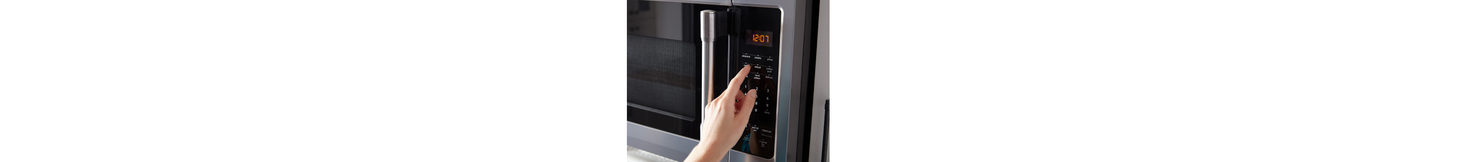 A finger making a selection on a microwave