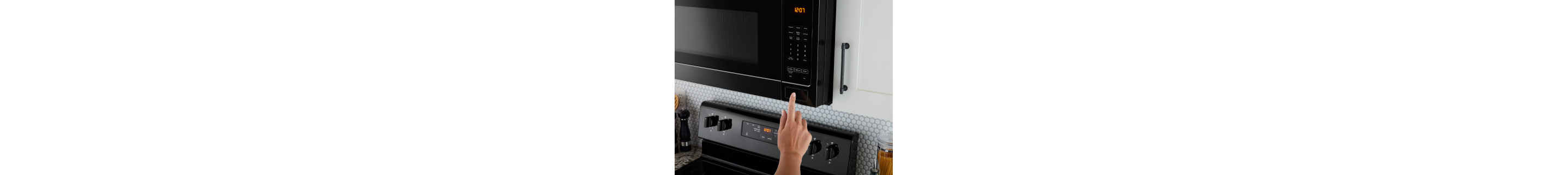 A finger pressing a button to start a microwave