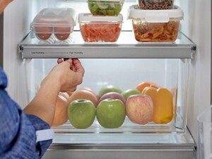 A hand adjusting the humidity of the crisper drawer