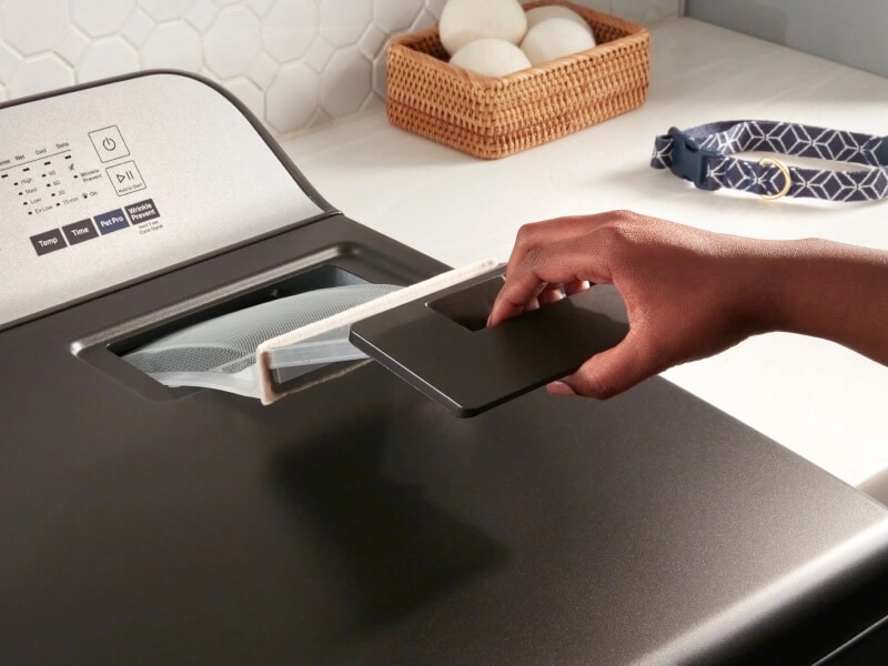 Person removing lint trap from dryer