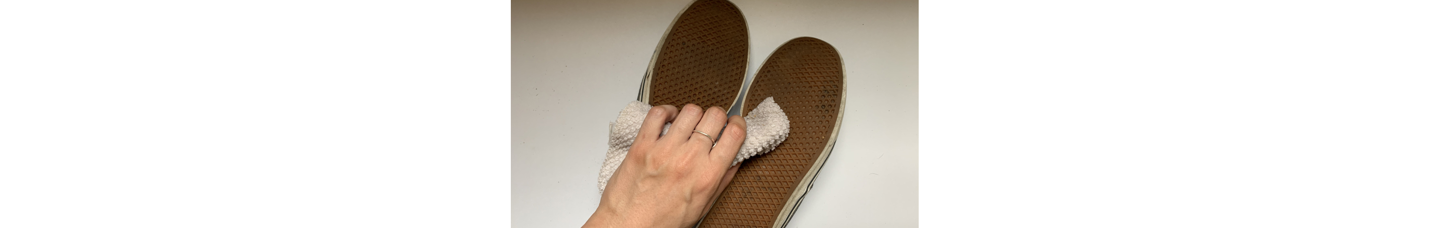Hand wiping soles of shoes with towel