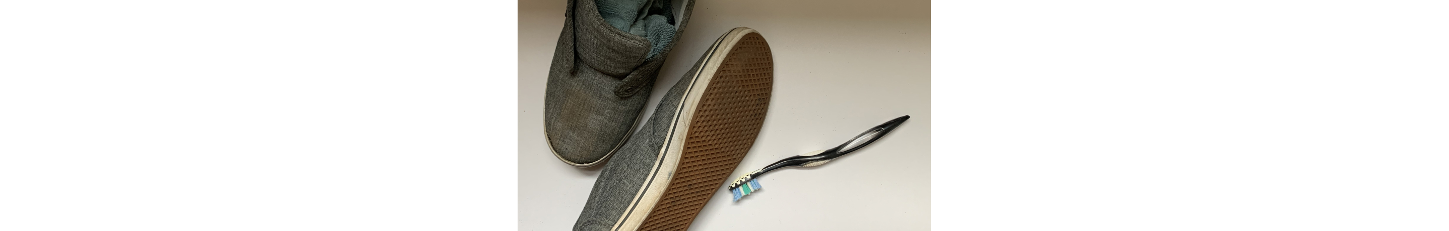 Shoes stuffed with rags next to a toothbrush 