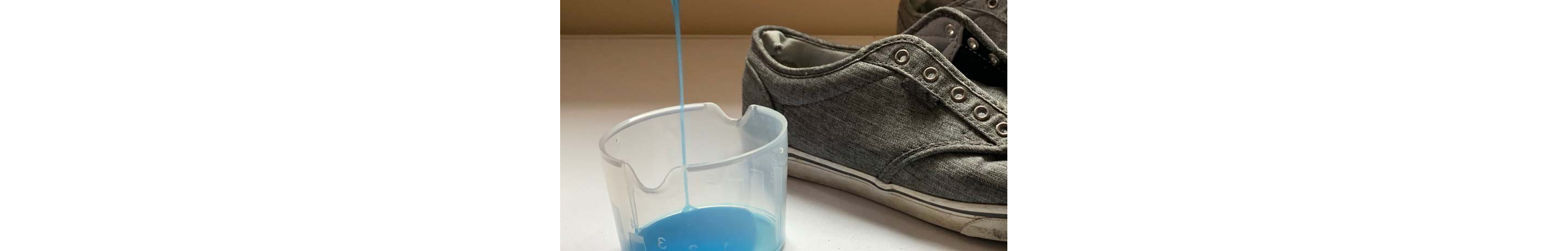 dish soap being dispensed into a small container next to shoes