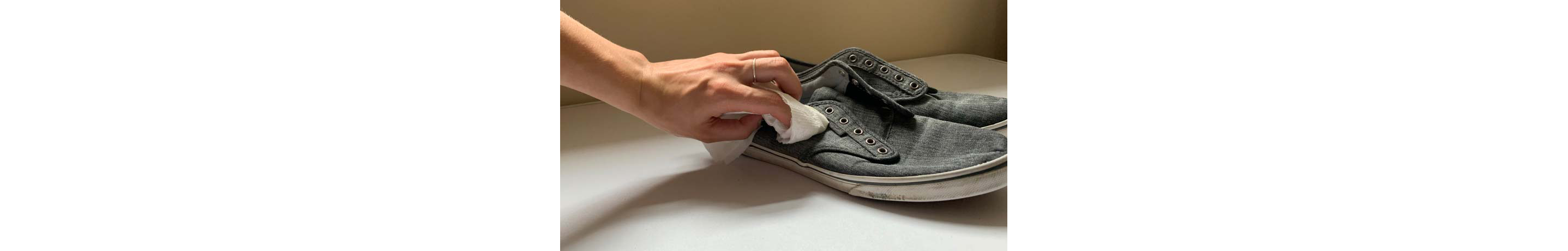 Hand wiping shoes with a clean paper towel