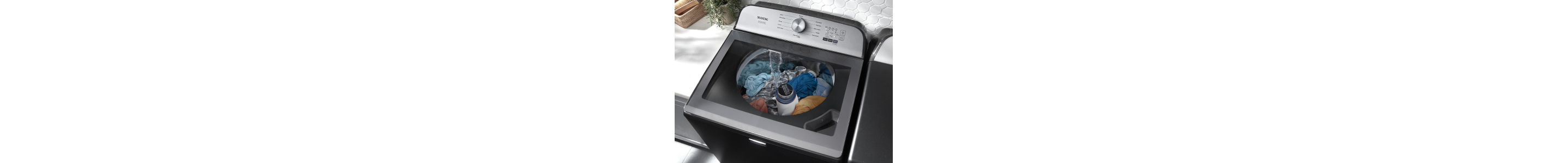 Top load washing machine from Maytag brand with see-through lid and clothes inside agitating