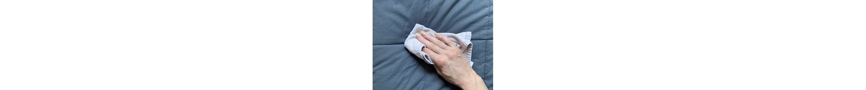 Person wiping blanket with washcloth