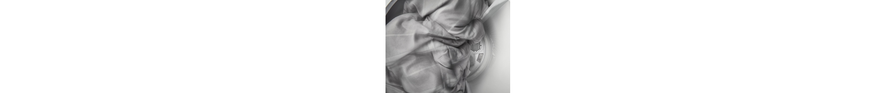 Gray blanket tumbling inside of dryer
