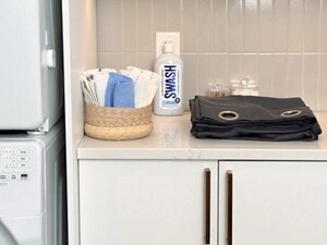 A folded curtain with Swash ® laundry detergent on a white marble counter