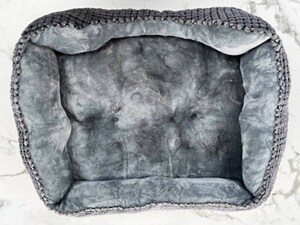 A dog bed with pet hair on it