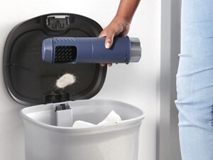 Person emptying the Maytag® Pet Pro Filter into a garbage can