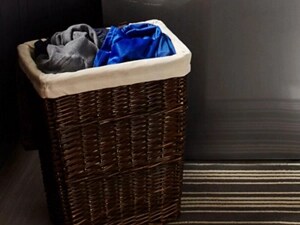 A hamper filled with laundry sorted by color