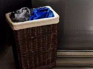 A hamper filled with laundry sorted by color