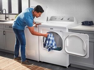  A man pulling a shirt out of the dryer