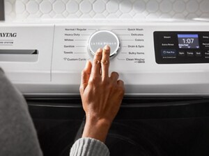 Someone operating the control panel of their Maytag® washer