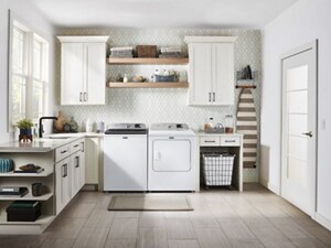 A white top load washer and dryer pair in a bright, sunny laundry area