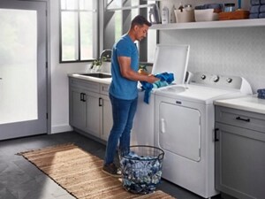 Person loading laundry into a top load washer
