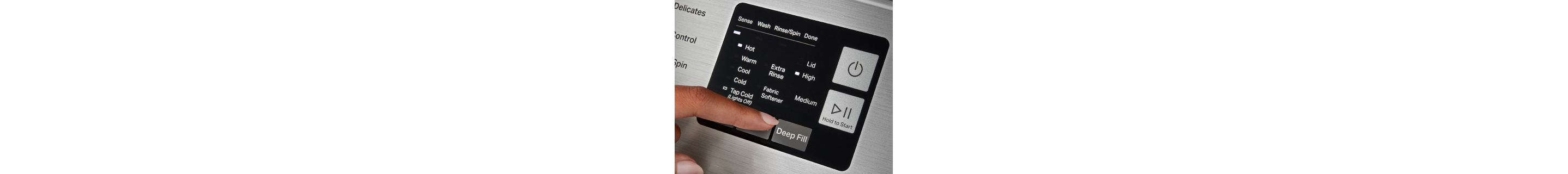 Close-up of person selecting washer settings on control panel