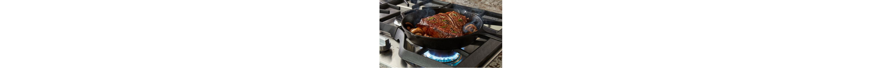Steak and mushrooms in cast iron skillet on gas cooktop