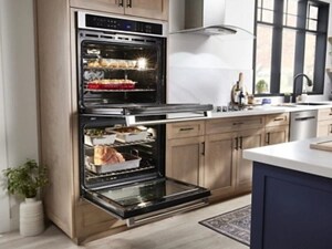 A kitchen with double wall ovens, open, with food inside