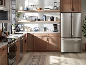 A kitchen with open shelving and a stainless steel fridge