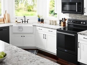 A kitchen with white cabinets and black appliances