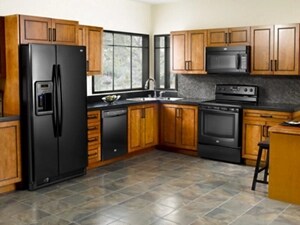 A kitchen with brown cabinetry and black appliances