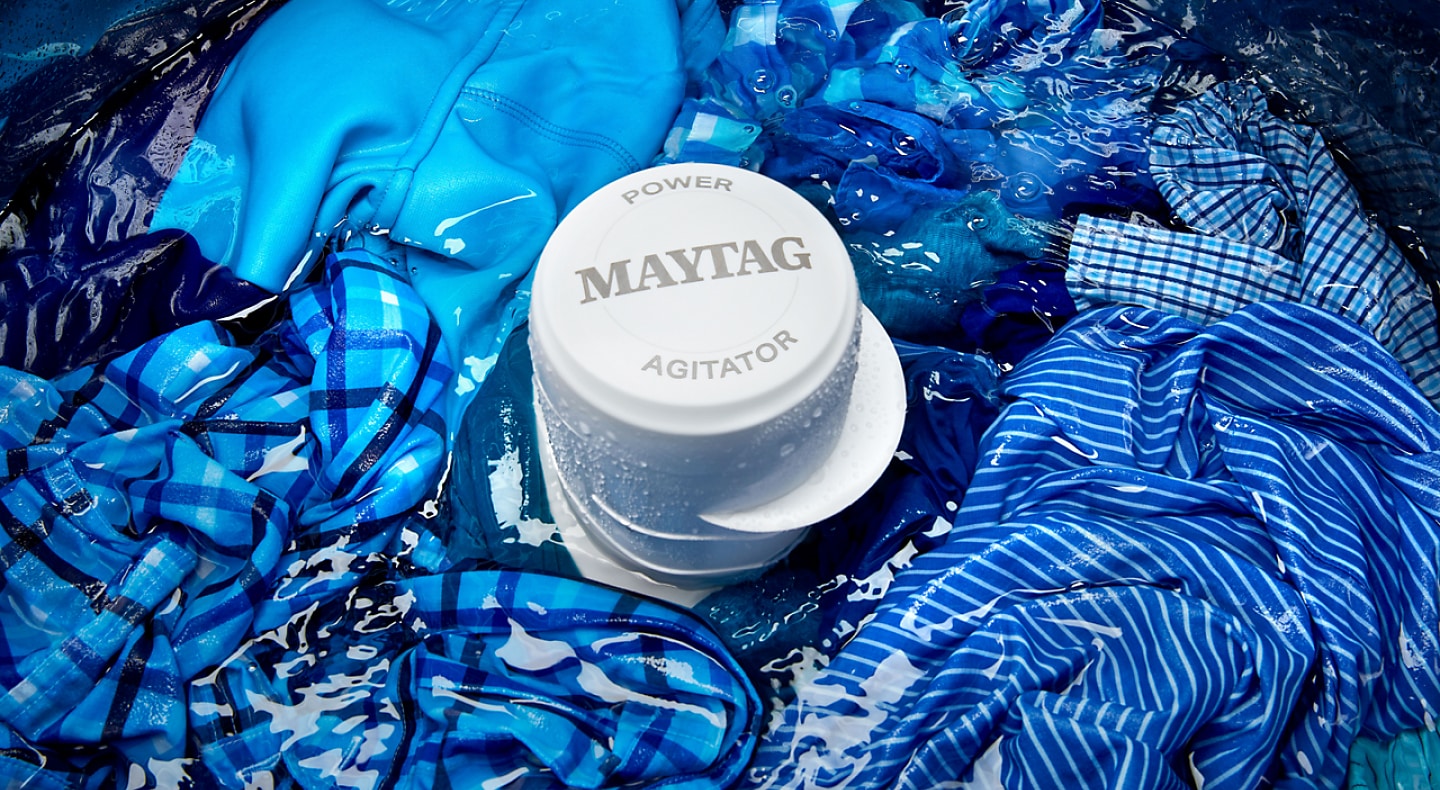 Blue clothes being washed in a Maytag® top-load washing machine