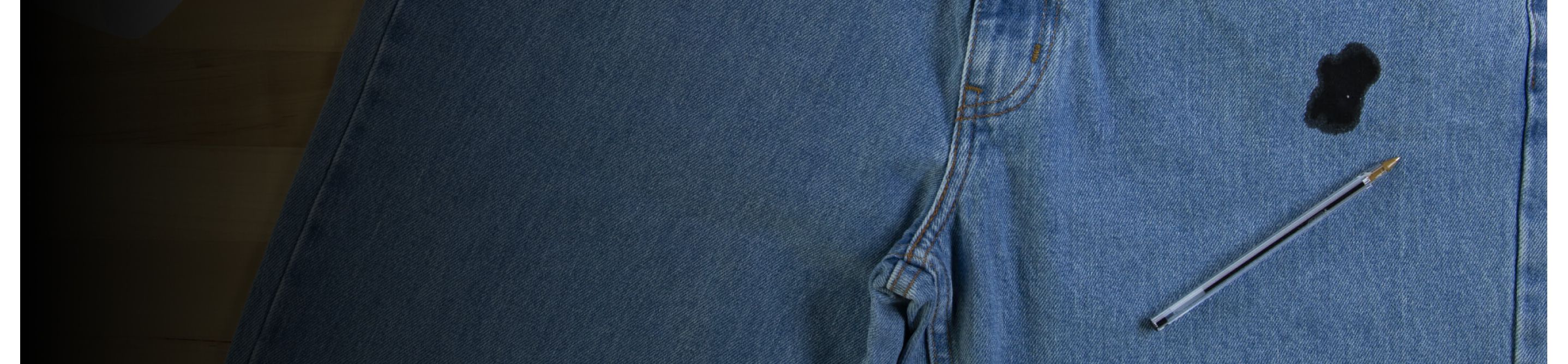 A pen on a pair of jeans stained with ink