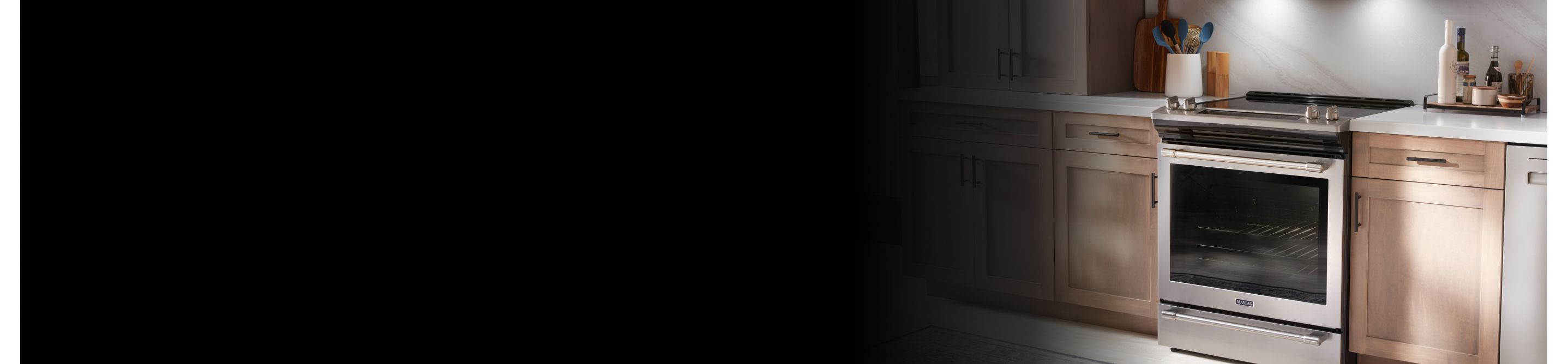 Stainless steel Maytag® electric range in brown cabinetry