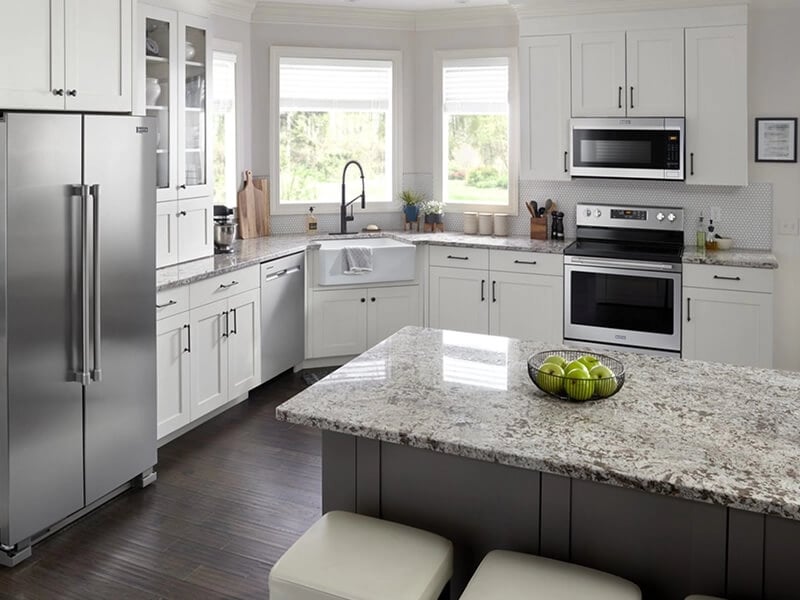 Suite of stainless steel Maytag® kitchen appliance in white cabinetry