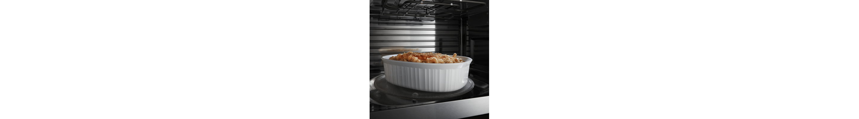 Image of white dish with food in it on microwave turntable
