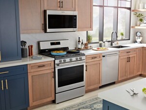 A bright kitchen with stainless appliances and a combination of wood and blue cabinets