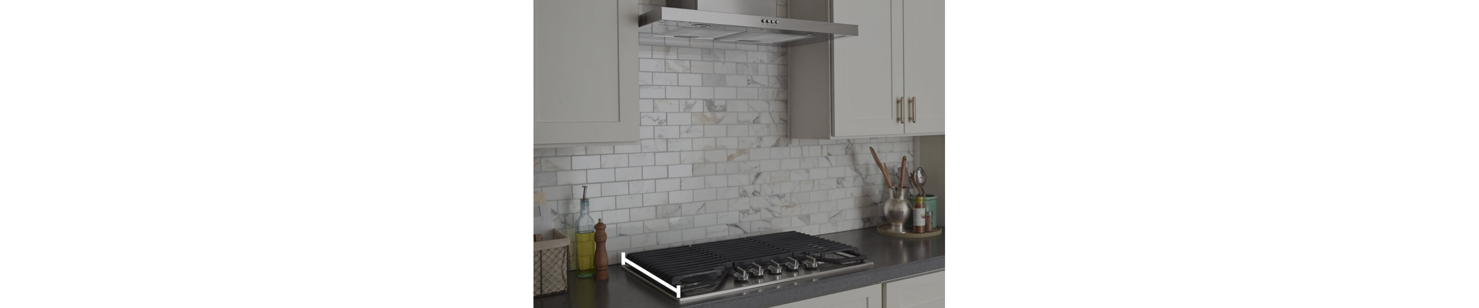 Range hood over cooktop with marks showing how to measure the cooktop