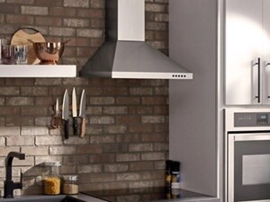 Range hood over cooktop next to wall oven