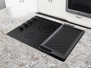 A Maytag brand cooktop set in a marble countertop