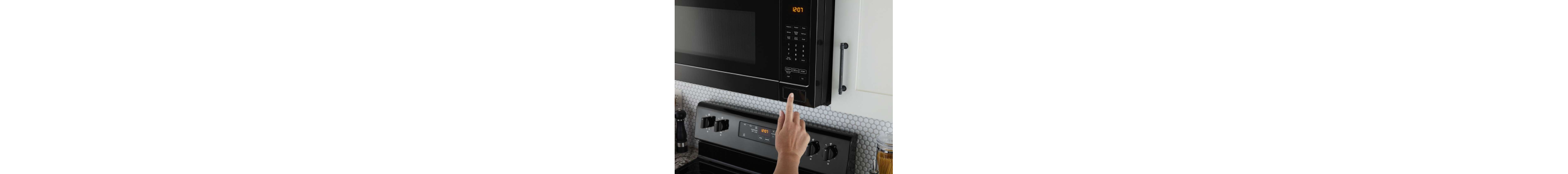 Hand pressing a button to open the microwave